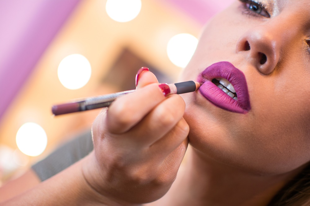 Transgender model applying makeup
